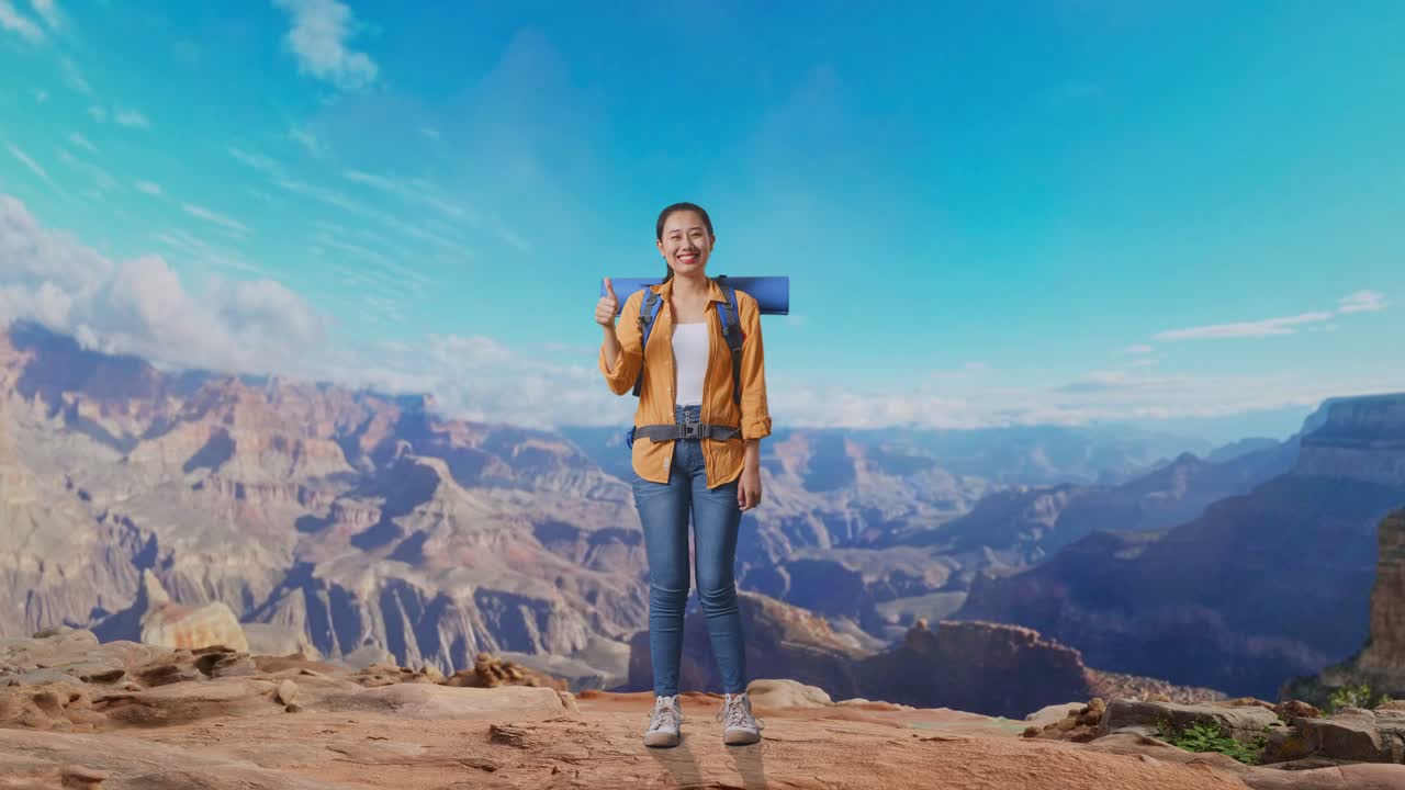 Full Body Of Asian Female Hiker With Mountaineering Backpack Smiling And Showing Thumbs Up Gesture To Camera While Traveling At The Top Of Mountain