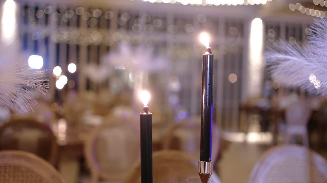 Soft candlelight flickers in an elegant dining setting with feather decor