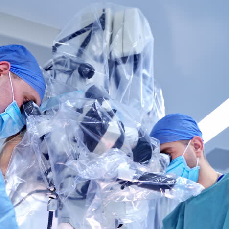 neurourgeons are operating with medical robotic surgery machine. manual control by minimally invasive surgical system. modern automated medical device. surgical room in hospital with robotic technology equipment, machine arm neurosurgeon. closeup of neurosurgery machine.