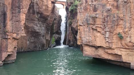 Aerial-shot-of-a-waterfall-surrounded-by-cliffs-in-South-Africa