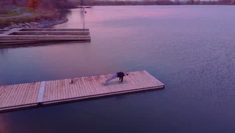 Vista-Aérea-De-Una-Mujer-Haciendo-Yoga-En-Un-Muelle