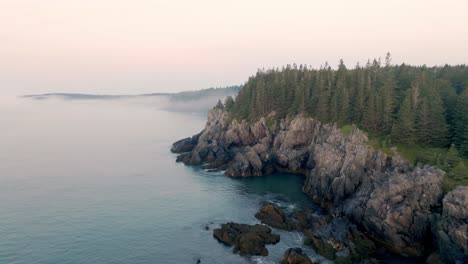 gorgeous aerial view captures maine's rugged cliffs shrouded in dawn fog