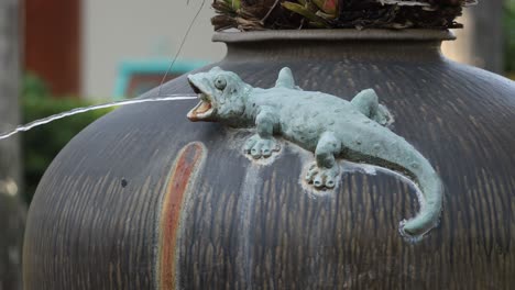 water streams through gecko sculpture on fountain