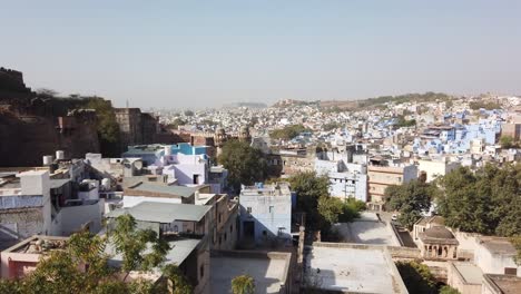 Tracking-Shot-Through-Window-of-Mehrangarh-Fort-to-Reveal-Blue-City-Below-at-Jodhpur,-Rajasthan,-India