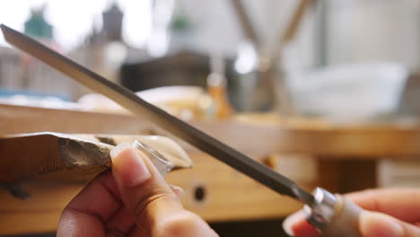 Close-Up-Of-Female-Jeweller-Working-On-Ring-With-File-In-Studio