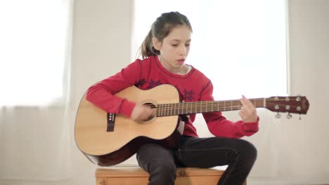 una joven tocando la guitarra y cantando
