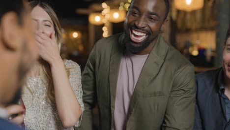 tracking shot of group of friends talking and laughing at a bar