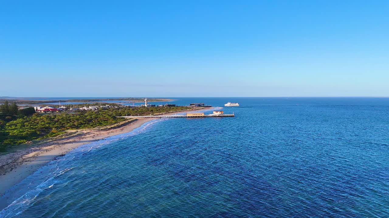 Drone footage captures Sorrento Pier and coastline under clear skies, showcasing serene ocean views and lush greenery