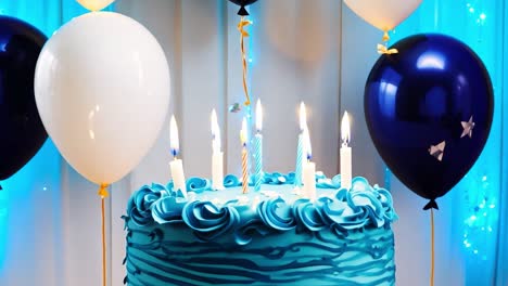 blue birthday cake with candles and balloons