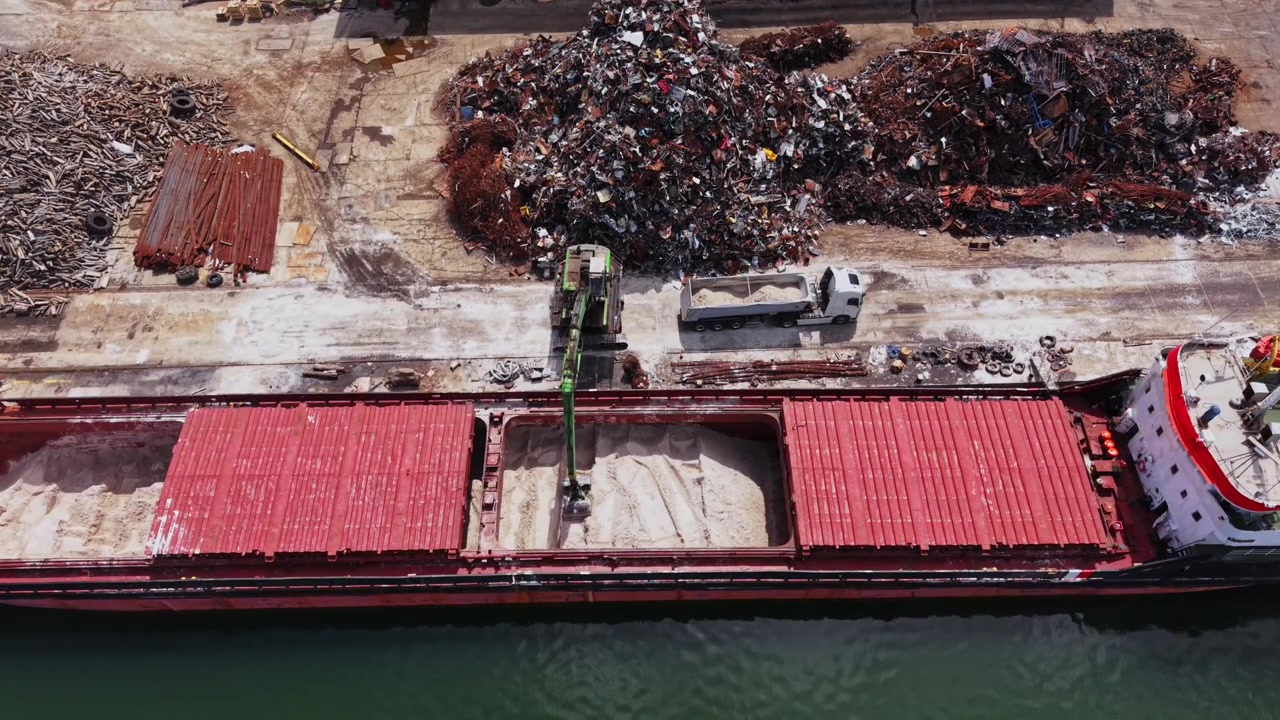 Il lavoro viene svolto nel cantiere navale con operazioni di scarico alla banchina.