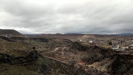 The-Virgin-River-and-rugged-gorge-towards-the-town-of-La-Verkin,-Utah---aerial-flyover