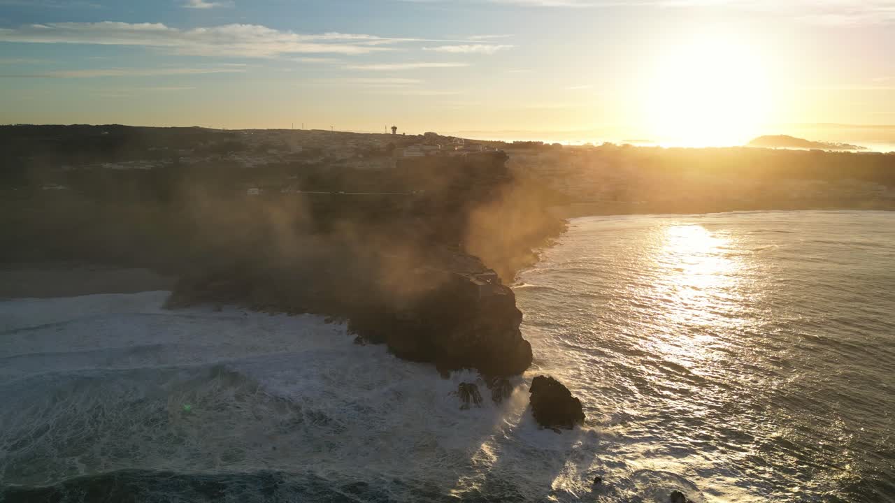Golden hour over rocky cliffs and the ocean near Farol da Nazaré, Portugal