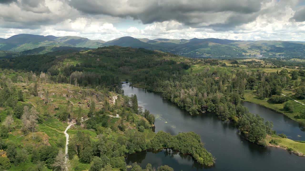 High Viewpoint Drone Aerial footage of Tarn Hows Lake District National Park England uk on a beautiful sunny summer day.