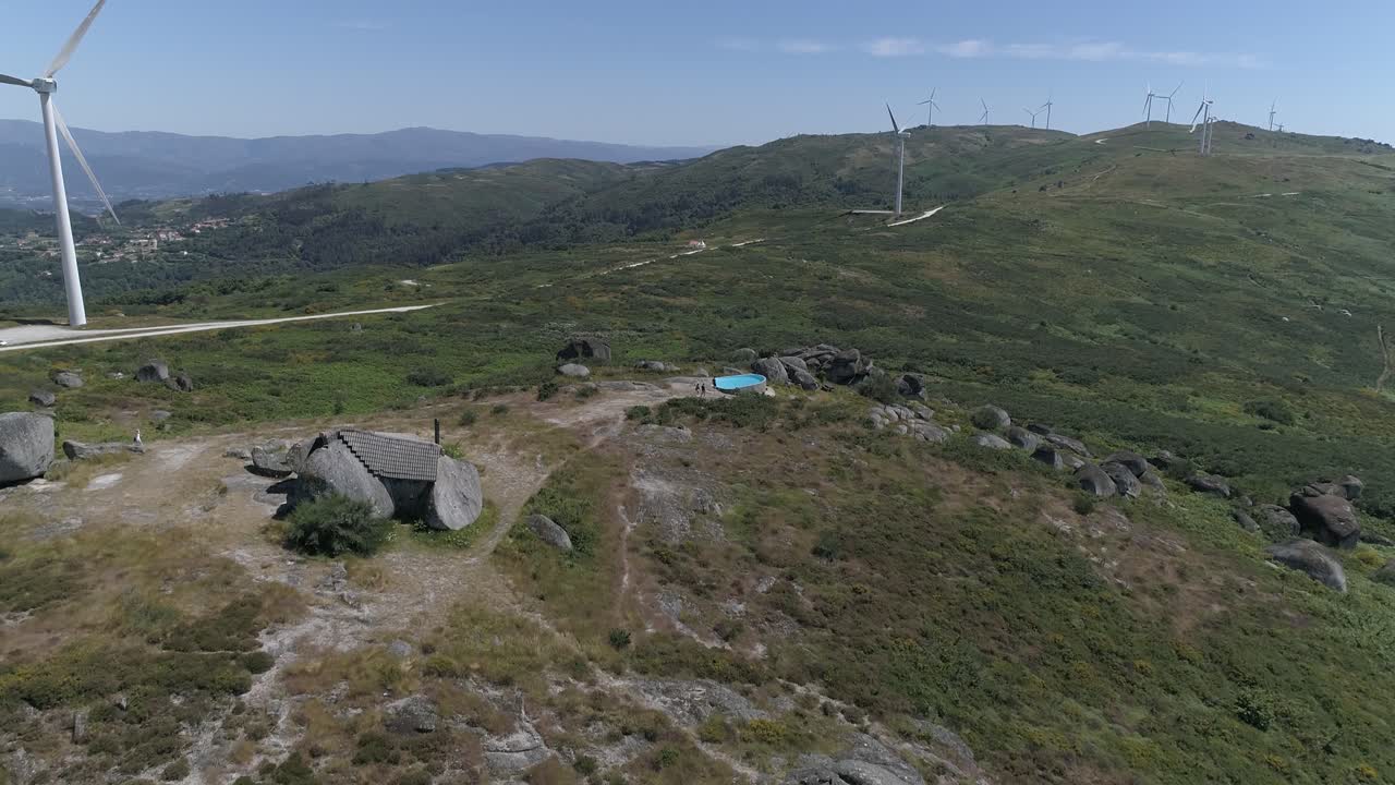 воздушный вид дома в горах с ветряными мельницами