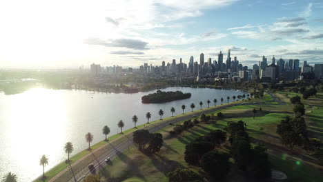 Suave-Y-Decente-Que-Revela-El-Lago-Albert-Park-Con-El-Tráfico-De-La-Hora-Pico-De-La-Tarde-Moviéndose-En-Una-Sola-Fila-Desde-El-Cbd-Hacia-Los-Suburbios