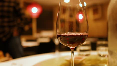 a wine glass in focus with a warm, ambient background in a gold coast venue. soft lighting enhances the intimate atmosphere
