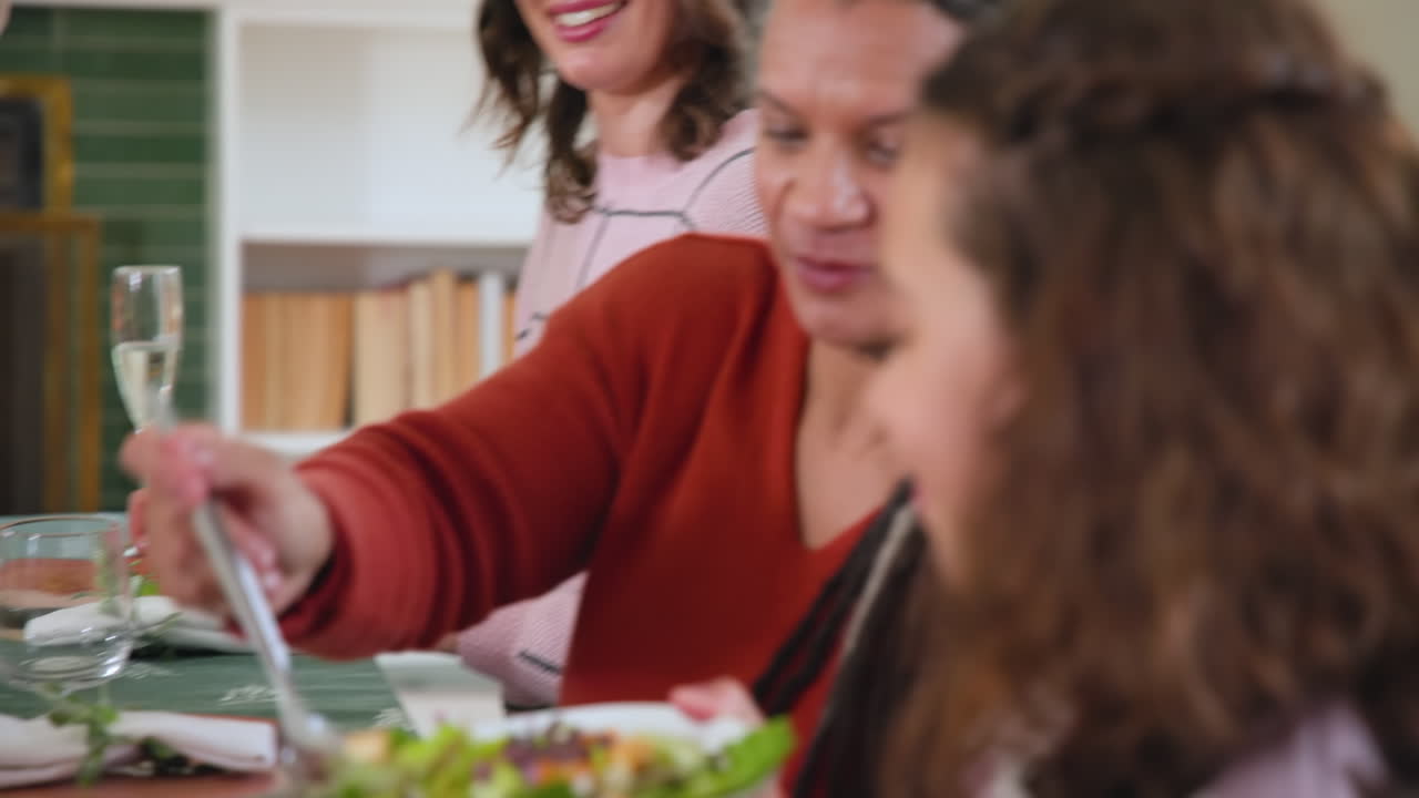 At Christmas, Diverse family enjoying festive meal together, sharing laughter and holiday cheer at h
