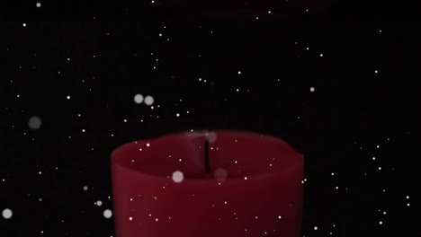 Animation-of-white-spots-of-light-floating-over-lit-red-candle-on-black-background