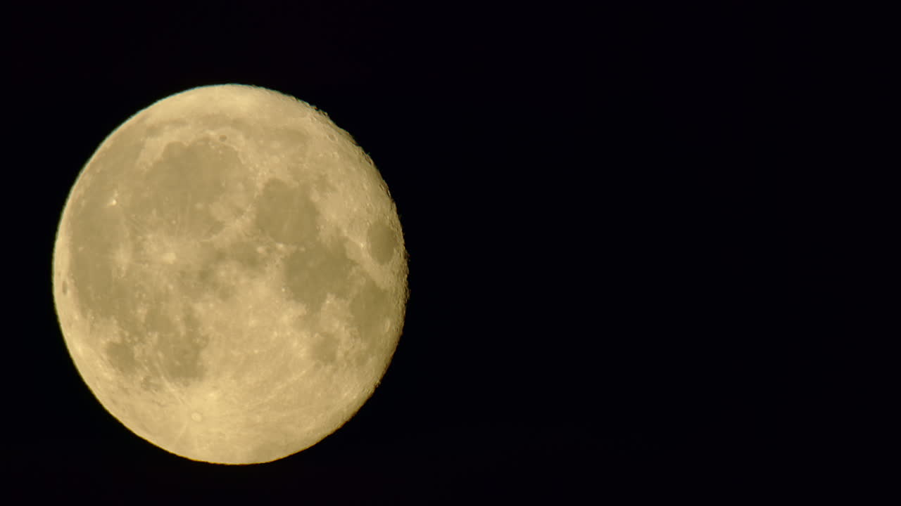 Lua cheia sendo coberta por nuvens escuras