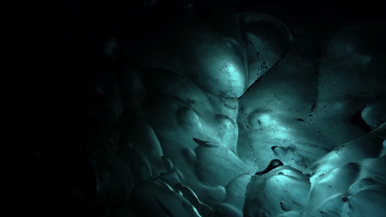 Stunning Iceland ice caves filled with shimmering blue ice, sculpted rippling glacial walls, and icy tunnels deep beneath the frozen Arctic surface