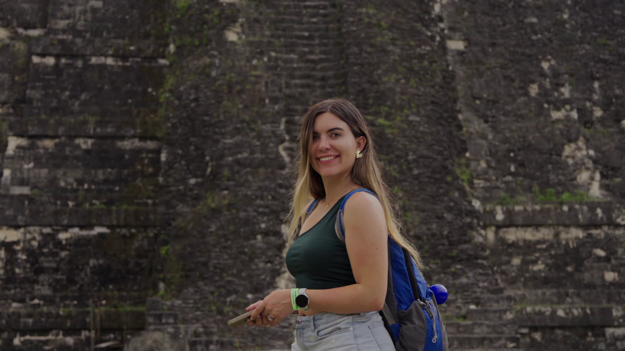 Happy tourist woman smiles in Tikal Guatemala pyramid temple. Wanderlust traveler. Joy. Slow motion