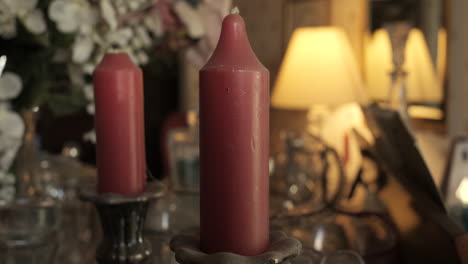 Burning-white-candles-in-a-glass-bulb-stand-wooden-terrace-of-country-hotel-decorated-with-wedding-bouquets-at-romantic-evening