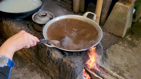 mujer asiática que hace azúcar de coco de palma hervida o proceso de producción de caña, materia prima