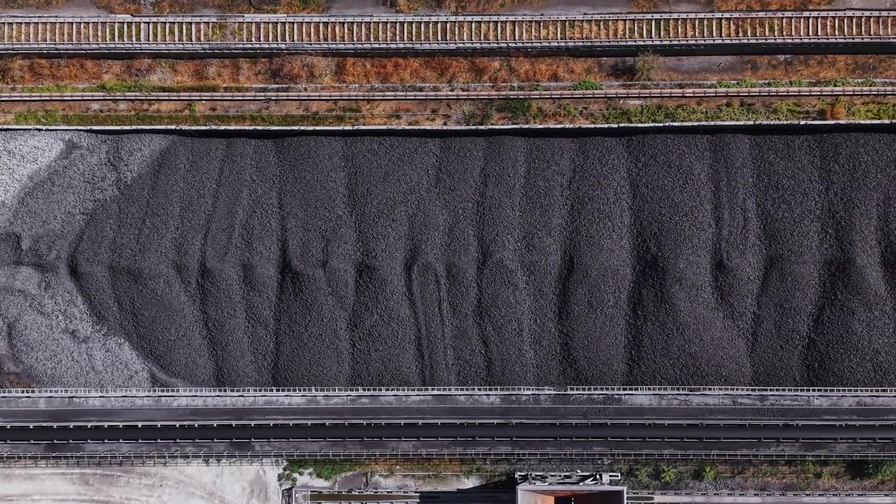 Coal pile stored near railway tracks in an industrial area