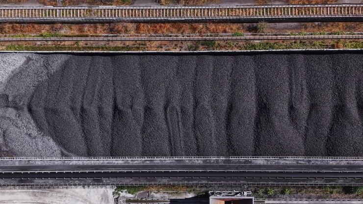 Coal pile stored near railway tracks in an industrial area