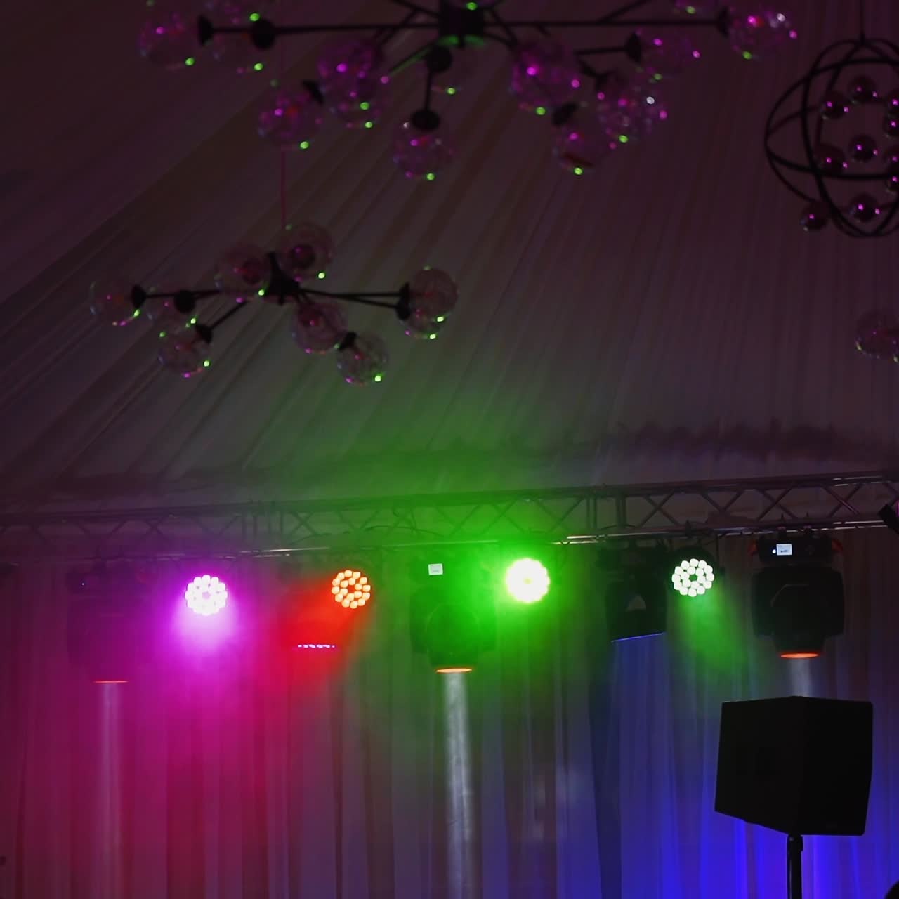 Professional lighting equipment on stage. Bright lasers and light rays emanating from central scene on musical dance show.