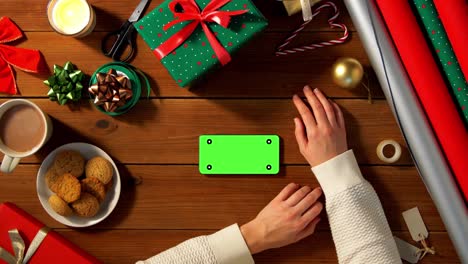 mujer con teléfono inteligente y café en navidad