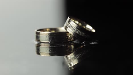 Anillos-De-Boda-Sobre-Una-Superficie-De-Agua-En-Blanco-Y-Negro-Que-Brilla-Con-Luz.-Primer-Plano