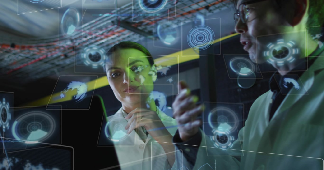 Two scientists standing in technical lab, tapping laptop screen and analyzing HUD data overlays