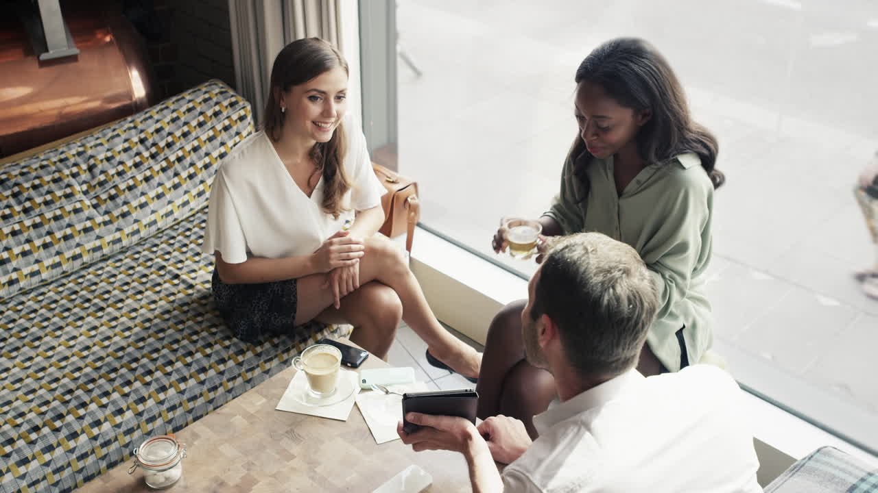 디지털 태블릿을 사용하여 카페에서 회의하는 비즈니스 사람들