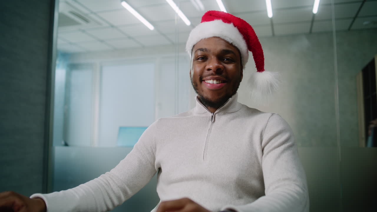 hombre con sombrero de papá noel en la oficina