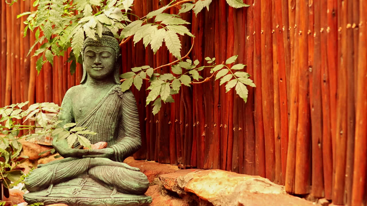 Tranquil garden with relaxing Buddha statue, lush leaves in the breeze