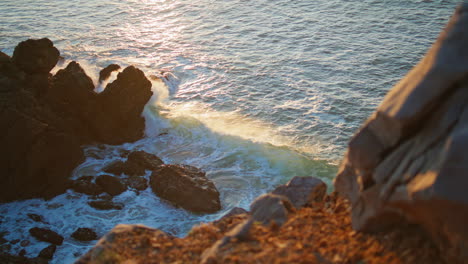 splashing waves covering rock at sunset closeup. cold sea water foaming evening