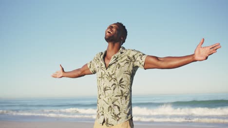 hombre afroamericano disfrutando del aire fresco en la playa