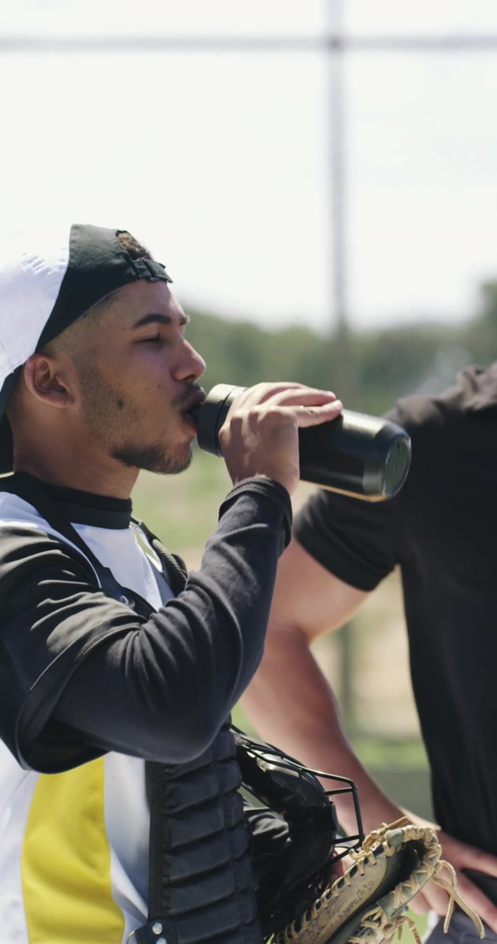 Ricevitore di baseball che beve acqua durante l'allenamento