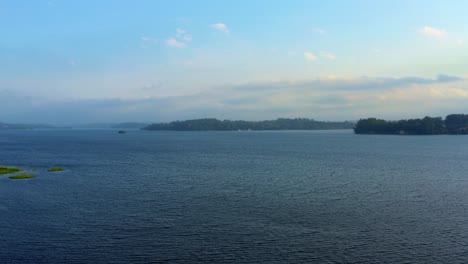 Beautiful-ascending-aerial-drone-shot-of-the-stunning-man-made-Guarapiranga-Reservoir-in-the-south-part-of-São-Paulo,-Brazil-with-beaches,-marinas,-and-wildlife-on-a-fall-evening