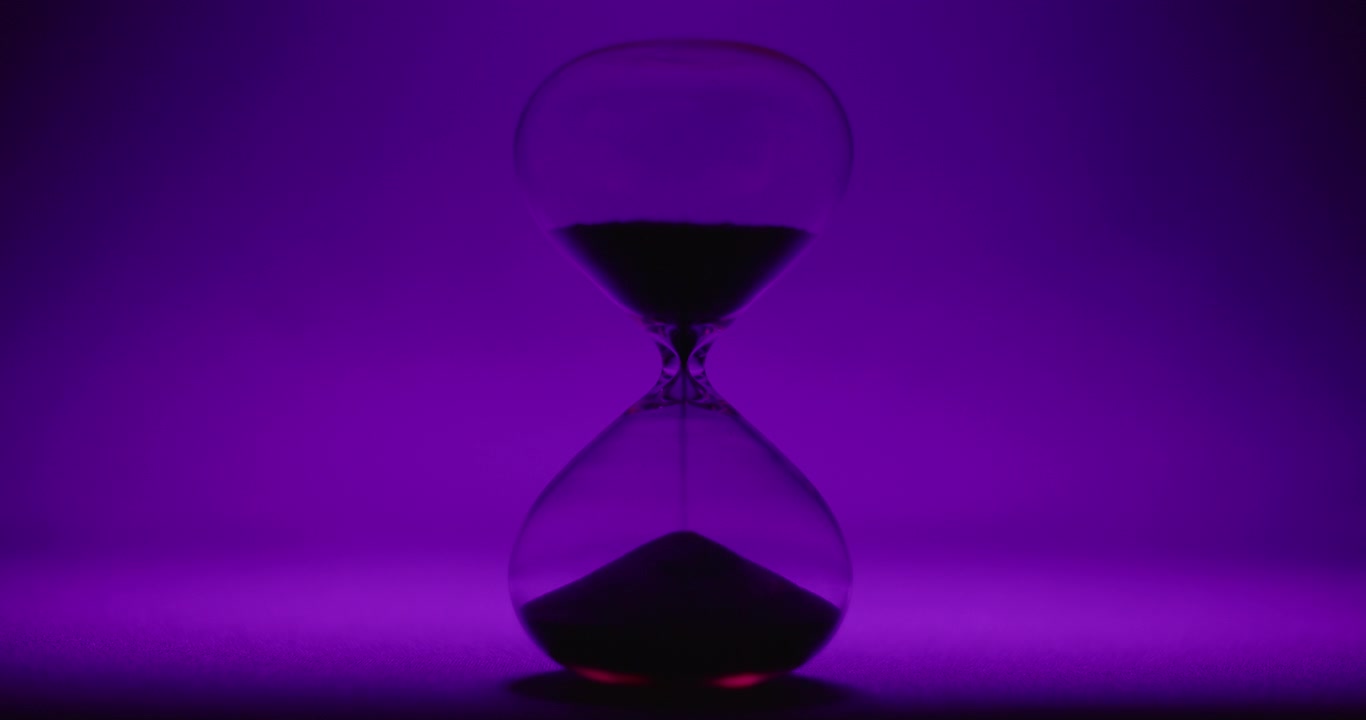 Hour glass on violet colored background