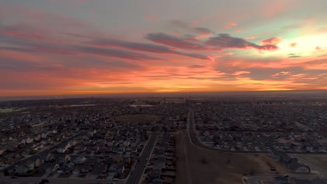 a drone flies forward over an epic urban sunrise in northern colorado