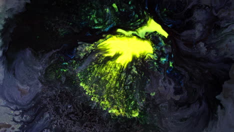 abstract macro view of vivid yellow pigment mixing in dark swirling liquid surface