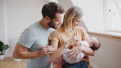 Cerca-De-Padres-Amorosos-Sosteniendo-A-Su-Hijo-Recién-Nacido-En-Casa-En-Un-Apartamento-Tipo-Loft