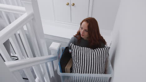 Female-College-Student-Carrying-Box-Up-Stairs-Moving-Into-Accommodation