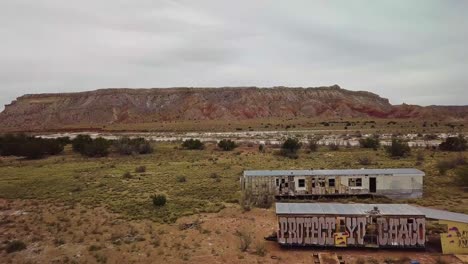 Vuelo-De-Drones-Sobre-Remolques-Abandonados-Con-Graffiti-En-Ellos-Al-Lado-De-La-Carretera