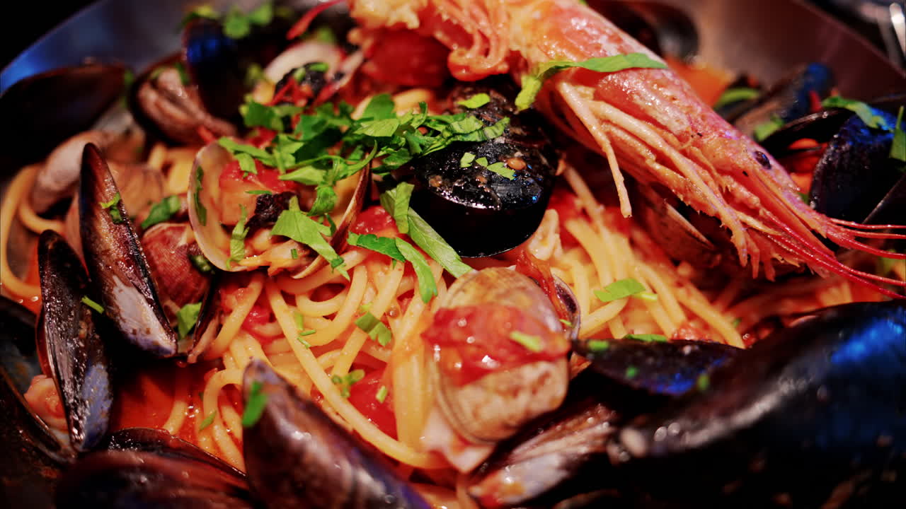 Close up of pasta with tomato sauce and mussels in a pan