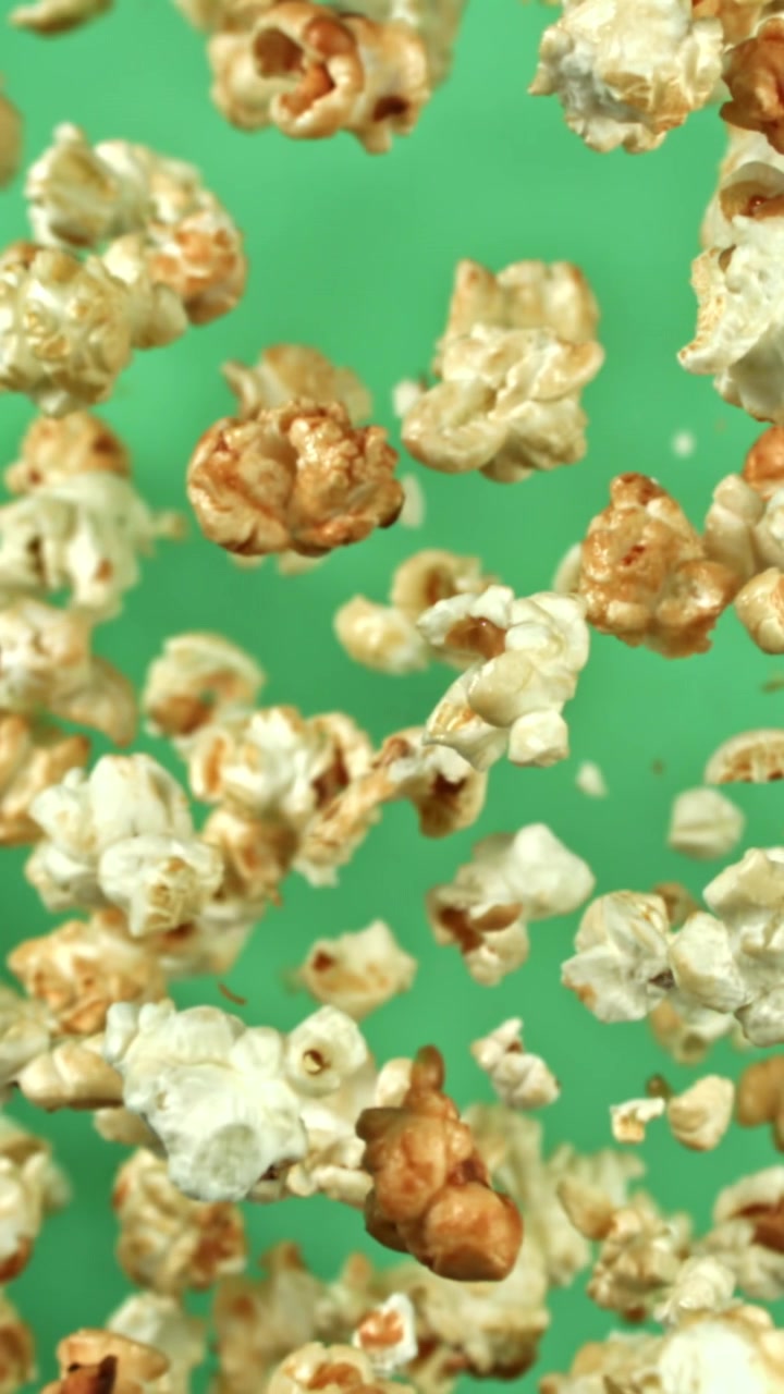 Popcorn che galleggiano e cadono al rallentatore su sfondo verde