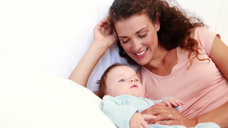 niño en azul babygro siendo cosquilleado por la madre