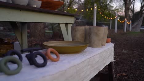 handmade cups and plates sit on a table